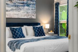 a bed with blue and white pillows and a window at The Sunny - Theme Parks , Heated Pool , Grill in Davenport