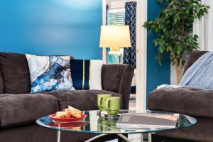 a living room with a couch and a table with a plate of food at The Sunny - Theme Parks , Heated Pool , Grill in Davenport