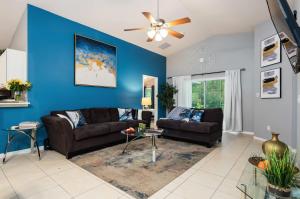a living room with two couches and a blue wall at The Sunny - Theme Parks , Heated Pool , Grill in Davenport