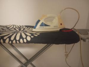 a iron is sitting on top of a bed at Room Flower Near Airport in Ariana +18 photos