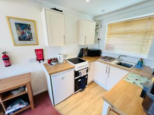 eine Küche mit weißen Schränken und einem Herd mit Backofen in der Unterkunft 2 Bedroom Chalet SB144, Sandown Bay, Isle of Wight, Dog Friendly, Free Wifi in Brading