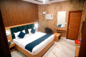 a bedroom with a large bed with blue pillows at Hotel Divine Stay in Amritsar +30 photos