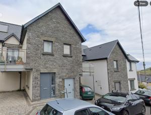 a brick house with cars parked in front of it at Ballycotton Seaview in Ballycotton