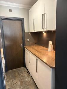a kitchen with white cabinets and a wooden counter top at The Bromley's in Great Yarmouth