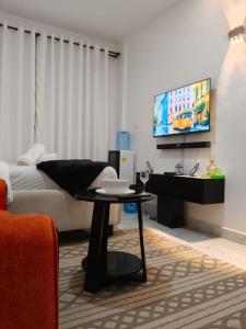un salon avec un lit et une télévision dans l'établissement Naivera, à Nairobi