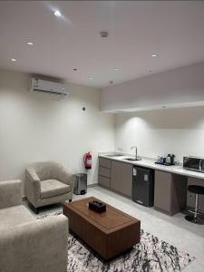 a kitchen and living room with a couch and a table at شقق جولدن إن للشقق المخدومة بجوار مستشفي السعود الالماني in Khamis Mushayt