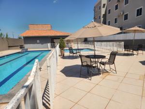 a patio with a table and chairs next to a pool at Morada Aconchegante com 2 quartos and Sofá Cama in Imperatriz