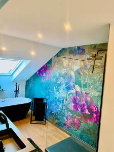un bagno con vasca e un dipinto sul muro di Heaven Homes XL - Luxusoase Balkon Parkplatz a Bad Camberg