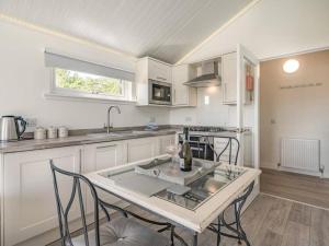 a kitchen with a table and some chairs and a sink at The Tranquil Orchard in Dumfries