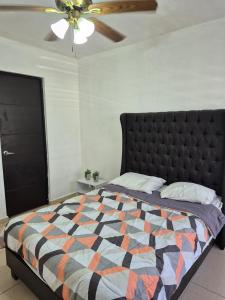 ein Schlafzimmer mit einem Bett und einem Deckenventilator in der Unterkunft Hermosa casa amueblada - Aeropuerto Monterrey in Monterrey