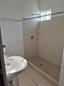 ein weißes Badezimmer mit Dusche und Waschbecken in der Unterkunft Hermosa casa amueblada - Aeropuerto Monterrey in Monterrey + 9 Fotos