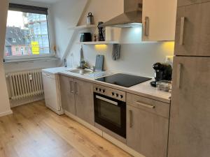 a kitchen with a sink and a stove top oven at CityLoft Wlan Zentral in Essen
