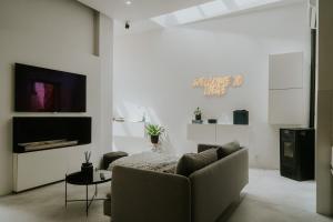 a living room with a couch and a tv at Luxury loft with private parking in Liège
