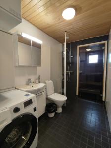 a bathroom with a sink and a washing machine in it at Convenient Apartment for 4 with Sauna in Joensuu