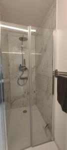 eine Dusche mit einer Glastür in einem Badezimmer in der Unterkunft Studio spacieux ,chaleureux et cosy in Heers