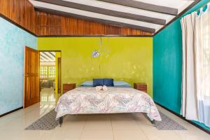 a bedroom with a bed and a green wall at Luna Caribena, lujosa casa tropical cerca cahuita in Cahuita +28 photos