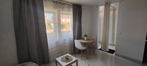 ein Raum mit einem Tisch und Stühlen und einem Fenster in der Unterkunft Studio spacieux ,chaleureux et cosy in Heers