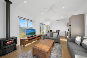a living room with a couch and a fireplace at The Shiraz Villa at Molly Morgan Wines in Rothbury