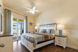 a bedroom with a bed and a ceiling fan at Casa Amarilla Cape Coral Luxury Waterfront Escape in Cape Coral Hospital Heliport +34 photos