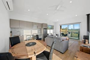 a kitchen and a living room with a wooden table at The Chardonnay Villa at Molly Morgan Wines in Rothbury