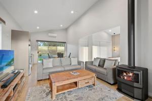 a living room with a couch and a fireplace at The Chardonnay Villa at Molly Morgan Wines in Rothbury +18 photos