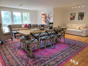 ein Wohnzimmer mit einem Tisch und Stühlen auf einem Teppich in der Unterkunft Kookaburra Cottage- views, wineries, sanctuary, in Healesville