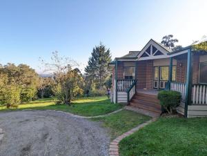 a brick house with a front porch and a driveway at Sandys Pottery Cottage- pet friendly, wineries, in Healesville