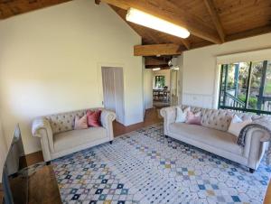 a living room with two couches and a rug at Sandys Pottery Cottage- pet friendly, wineries, in Healesville