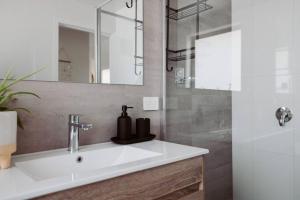 une salle de bain avec un lavabo et un miroir dans l'établissement The Drift Haus- Shearwater, à Port Sorell 38 autres photos