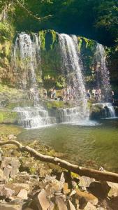 a group of people standing in a waterfall at Forest Retreat Log Burner Dog Friendly Wifi in Cymmer