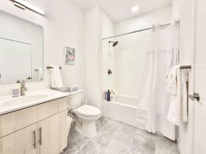 a white bathroom with a toilet sink and a shower at Central Philly 1Br Apt with Gym in Philadelphia +25 photos