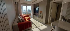 a living room with a couch and a large window at Apto Imperial Villa di Tondo in Bento Gonçalves