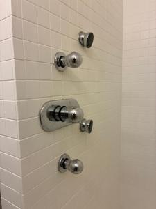 a shower with silver fixtures on a white tiled wall at Appartement historisch centrum Antwerpen in Antwerp +30 photos