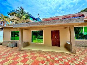 a small house with a red door on a patio at Isamilo House in Mwanza