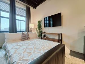a bedroom with a large bed and a flat screen tv at Cozy Philly Studio with Free Parking for Long Term Stays in Philadelphia