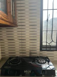 a stove top in a kitchen next to a window at Mashingo Homestay in Dar es Salaam