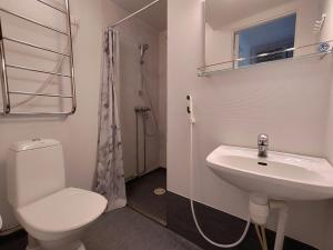 a white bathroom with a toilet and a sink at Central Apartment for 4 in Kemi