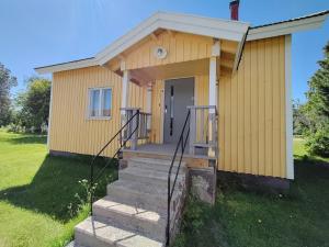 a small yellow house with stairs leading to a door at Central Apartment for 4 in Kemi