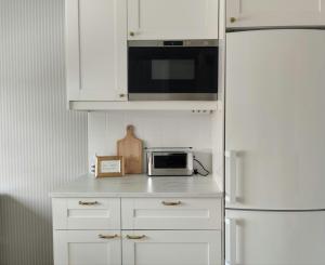 a white kitchen with a microwave and a refrigerator at Convenient Apartment for 4 in Kemi +10 photos