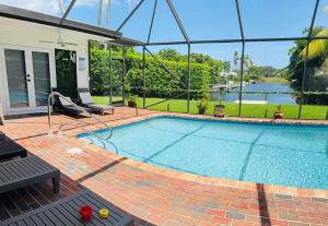 a large swimming pool in a yard with a house at Serenety Shores in West Palm Beach