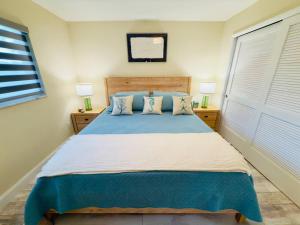 a bedroom with a large bed with blue sheets and pillows at Serenety Shores in West Palm Beach +23 photos