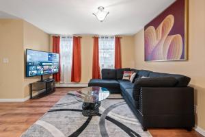 un salon avec un canapé et une télévision dans l'établissement Cozy Two Bedroom in Brooklyn, à Brooklyn