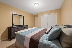 une chambre avec un lit et une commode avec un miroir dans l'établissement Cozy Two Bedroom in Brooklyn, à Brooklyn