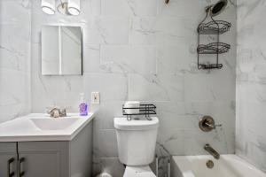 une salle de bains blanche avec toilettes et lavabo dans l'établissement Cozy Two Bedroom in Brooklyn, à Brooklyn 8 autres photos