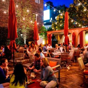 un groupe de personnes assises dans un restaurant la nuit dans l'établissement Cozy Two Bedroom in Brooklyn, à Brooklyn