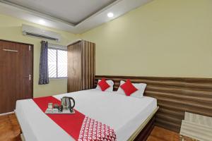 a bedroom with a large white bed with red pillows at Hotel O Maheshwari Residency in Rānchī