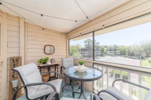 a screened porch with a table and chairs and a large window at The Beachwalker Relax & Renew in Hilton Head Island