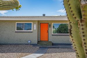 a house with an orange door and a cactus at Tucson Oasis by Rather Be Properties in Tucson +43 photos