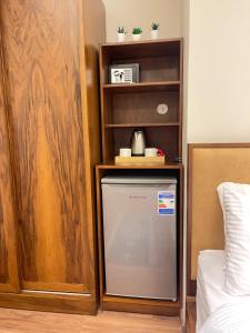 a small refrigerator in a room next to a book shelf at Sheraton Pearl in Alexandria
