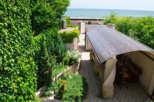 a garden with a bench and an umbrella at Raduga 514 in Zatoka